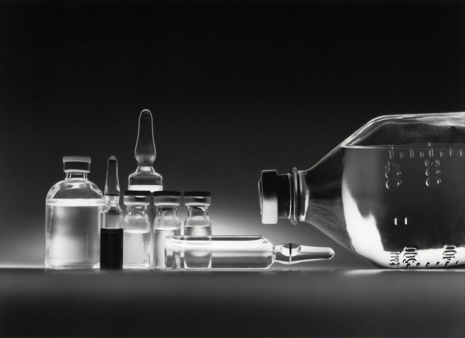 Glass medical vials on a dark surface